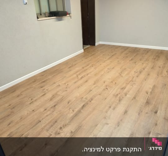 רצפת פרקט עץ בהירה בחדר ריק עם קירות בהירים